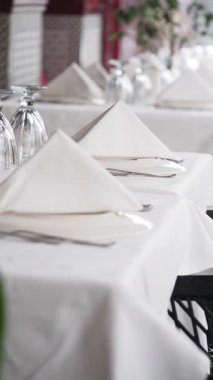 Beyaz çarşafları ve cam örtüleri olan zarif masalar misafirleri bekliyor..