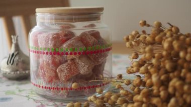 Renkli ev yapımı şekerler kurumuş çiçeklerin yanında bir kavanozda güzelce sergilenir..