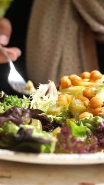 Bir insan sebze ve nohut dolu canlı bir salatadan hoşlanır..