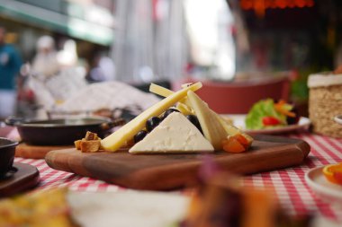 Tahta, rengarenk malzemeli çeşitli peynirler sergiliyor..