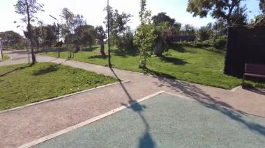 Yol ve yeşillik içeren yerel bir parkta aydınlık bir günün tadını çıkarın..