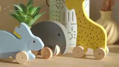 Üç sevimli hayvan oyuncağı masaların üstünde parlak renklerde yuvarlanıyor..