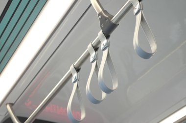 Yolcular temiz ve parlak bir tren kulübesinde kayışlara tutunurlar..