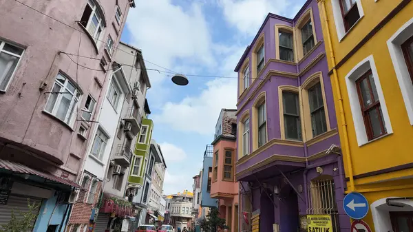 Parlak renkli binalar mavi gökyüzünün altındaki dar sokaklar boyunca uzanır..