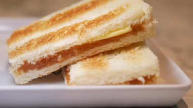 Kaya tostu tereyağlı ve kaya tostlu iki dilim tosttan oluşur..