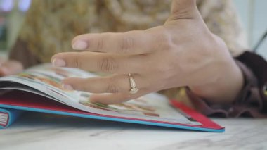 Bir el menüyü araştırıyor, öğle yemeğinde arkadaşlarla seçenekleri tartışıyor..