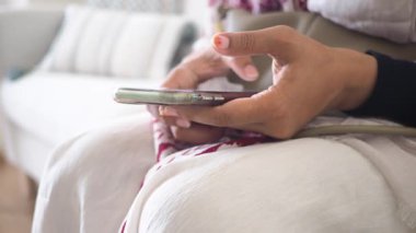 Bireysel rahatlar ve kanepede akıllı bir telefonla etkileşime girer..