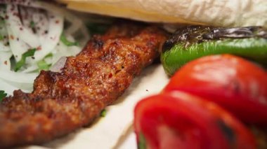 Taze sebze ve baharatla servis edilen leziz ızgara kebabın tadını çıkarın..