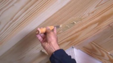 Tahta kirişlerdeki çizikleri pürüzsüz bir son için macun bıçağı kullanarak düzeltiyorum..