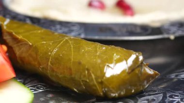 Sıcak bir masada renkli taze sebzelerin yanında lezzetli bir dolmanın tadını çıkar..