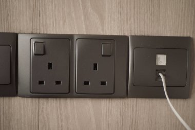 Pürüzsüz bir duvar tasarımında birbirine bağlı bir cihazla çoklu elektrik prizleri.
