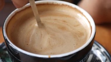 Müşteriler bir kafede koştururken, zengin bir içeceğin tadını çıkarıyorum..