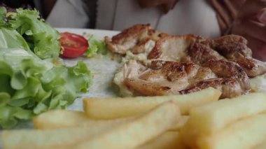 Kızarmış tavuğun yanında canlı salata ve kızarmış patatesin tadını çıkarın..