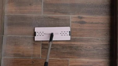 Bir evde ahşap döşemeleri temizlemek için paspas kullanılıyor..