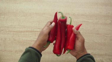 Elleri canlı kırmızı biber tutar. Yemeklere baharat katmak için birebirdir..