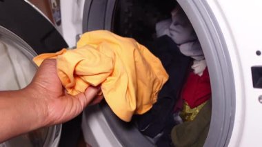 Kurutmak için temiz çamaşırları kurutucuya koyarlar..