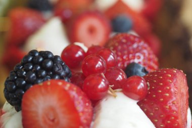 Canlı çilekler, böğürtlenler ve ahududular tatlıyı güzelleştirir.