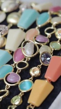 Değişik şekil ve renklerde mücevherler koyu bir arkaplanda zarifçe sergilenir..