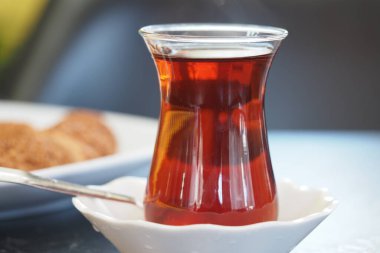 Bir fincan buharlı Türk çayı ve masada kurabiyeler..