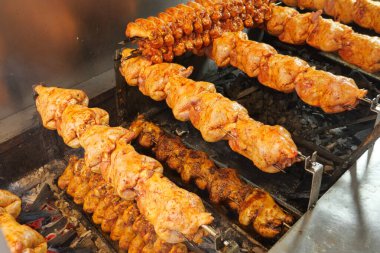 Kızarmış tavuk, açık hava pazarında kömür üstünde pişiyor..