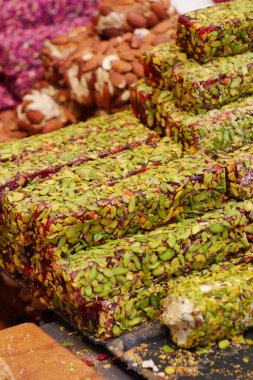 Renkli şam fıstığı tatlıları canlı bir markette güzelce istiflenmiş..