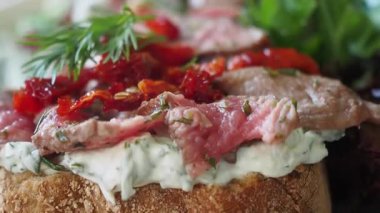 Bitki ve sebzelerle kaplı bir etli sandviçin yakın çekiminin tadını çıkar..