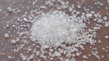 Tahta bir yüzeye yavaş yavaş beyaz şeker düşer.,