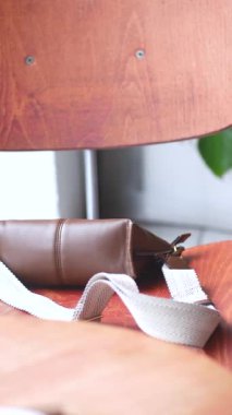 Deri çanta tahta sandalyede dinleniyor. kayıp çanta kavramı ,