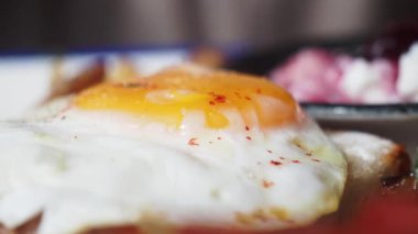 Kızarmış yumurtayı tostun üstünde kesiyorum..