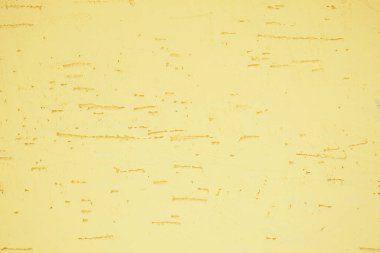 Kalıplı sarı bir duvar benzersiz kusurlar ve desenler gösterir..