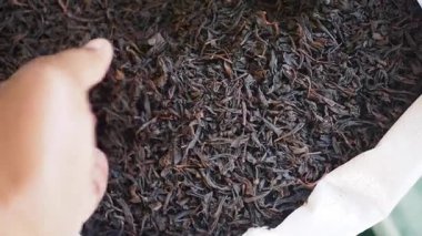 Bir el, aromasını vurgulamak için market poşetinden yaprak çayı alır..