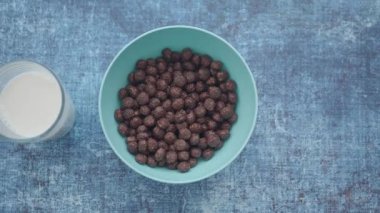 Çikolatalı mısır gevreği soğuk sütün yanında bir kasede servis edilir..