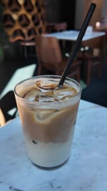 Sıcak bir öğleden sonra, yerel bir kafede lezzetli bir buzlu kahve yudumluyordu..