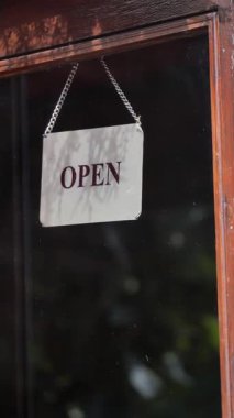 Mağazanın açık olduğunu gösteren bir tabela. Müşterileri içeri davet ediyor..