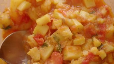 Sıcak bir mutfakta hazırlanmış lezzetli bir patates ve domates karışımı..