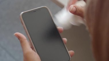 Telefonunu mendille temizleyen kadının dikiz görüntüsü ,