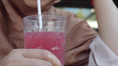 Arkadaşlarla dışarıda dinlenirken renkli bir içeceğin tadını çıkarıyorum..