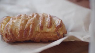Taze pişmiş hamur işi, altın kabuğuyla baştan çıkarıcı ahşap bir masada bekliyor..