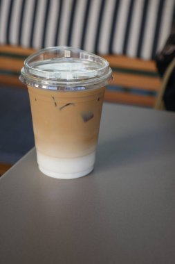 Rahatlatıcı bir buzlu kahve rahat bir kafede bir masada oturur..