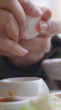 Haşlanmış yumurta soyan eller.,