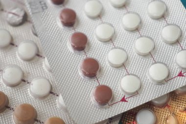 Organize su toplamada farklı renkte doğum kontrol hapları..