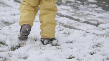Bir çocuk kış manzarasını keşfederken yoğun karda yürür..