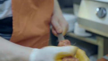 Şef canlı bir mutfak ortamında içinde taze malzemeler olan kebaplar hazırlar..