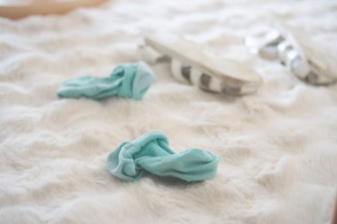 İki yumuşak mavi çorap ve sandalet yumuşak bir halıya saçılmış..