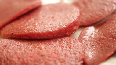 İnce dilimlenmiş kırmızı etin yakın plan görüntüsü bir tabakta güzelce dizilmiş.