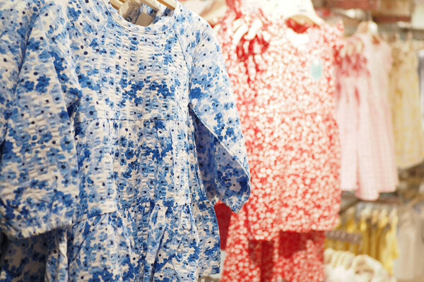 Красочные детские платья в магазине отображают разнообразные дизайны.