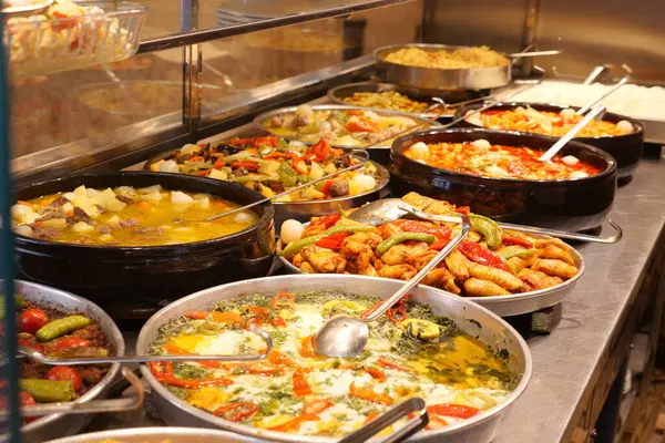 Bir markette metal tepsilerde çeşitli canlı yemekler sergileniyor..