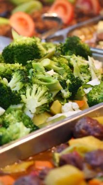 Taze buharda pişirilmiş brokoli ve diğer çeşitli yemekler büfede servis edilir..