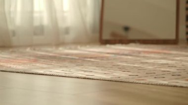 Güzel düzenlenmiş bir odada şık bir halı ve yumuşak doğal ışık vurgulanıyor..