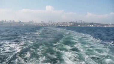 Istanbullar dalgalarda dolaşırken ufuk çizgisinin huzurlu manzarasının tadını çıkar..